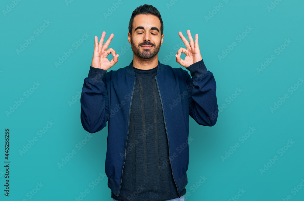 Young hispanic man wearing casual clothes relax and smiling with eyes closed doing meditation gesture with fingers. yoga concept. Young hispanic man wearing casual clothes relax and smiling with eyes closed doing meditation gesture with fingers. yoga concept.