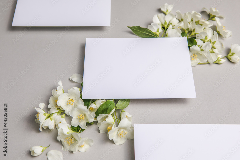 Mock up with attached natural fresh jasmine flowers on a gray background, copy space. Mock up with attached natural fresh jasmine flowers on a gray background, copy space.