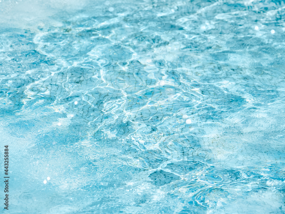 Sun beams on surface of water in swimming pool or fountain with blue mosaic bottom. Abstract background with wavy pattern of clear transparent water. Sun beams on surface of water in swimming pool or fountain with blue mosaic bottom. Abstract background with wavy pattern of clear transparent water.
