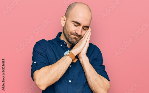 Young hispanic man wearing casual clothes sleeping tired dreaming and posing with hands together while smiling with closed eyes.