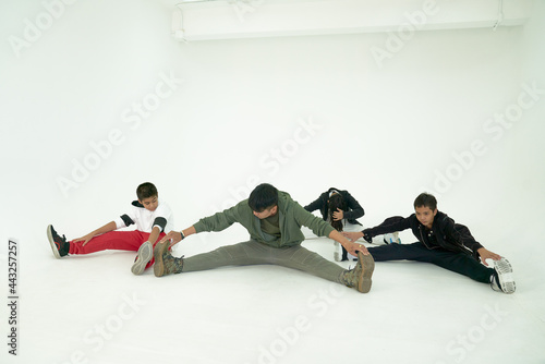 Trainer and group of childen worming up before start to train in dancing calss in white room photo