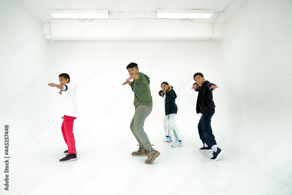 Fototapeta premium Dancing childen class concept , with boys and girld trained with trainer in white studio room for hobby time of child