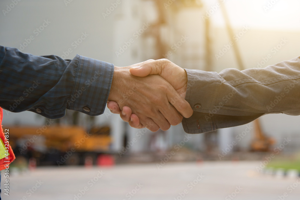 Fototapeta premium Close-up image of a firm handshake between two colleagues on site of building construction