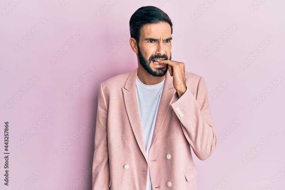 Young hispanic man wearing business jacket looking stressed and nervous with hands on mouth biting nails. anxiety problem. Young hispanic man wearing business jacket looking stressed and nervous with hands on mouth biting nails. anxiety problem.