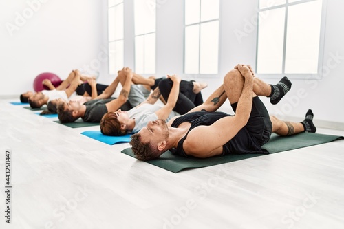 Group of young sporty people concentrate stretching at sport center.