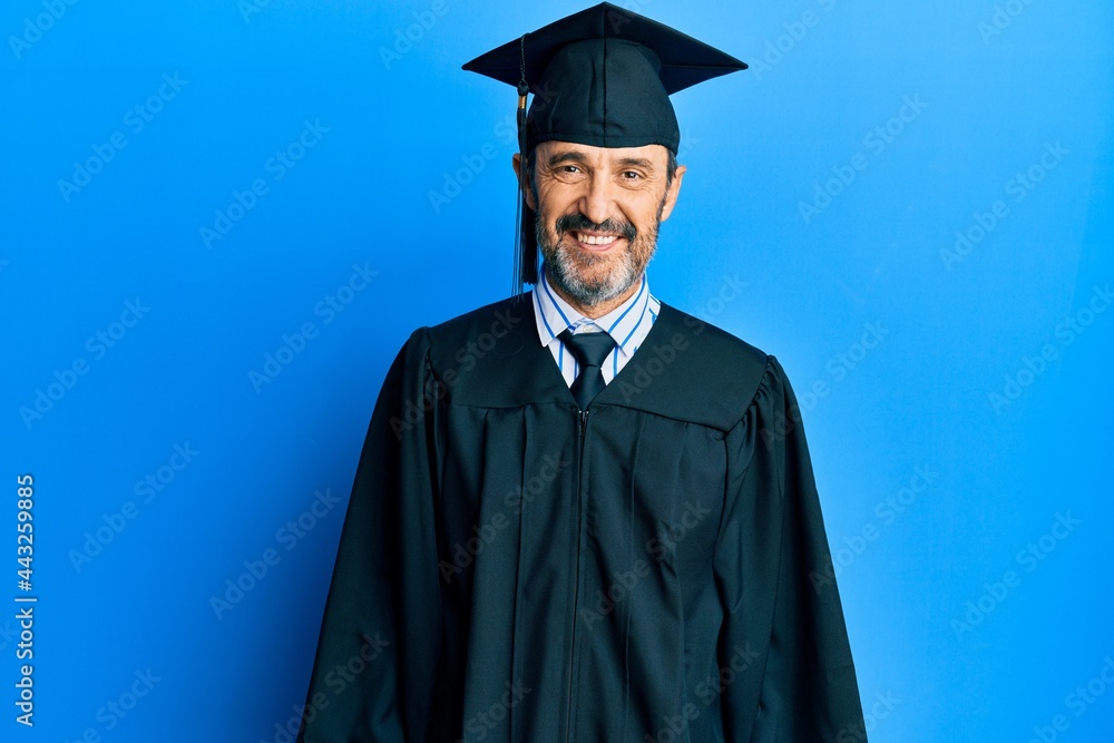 Middle age hispanic man wearing graduation cap and ceremony robe with a happy and cool smile on face. lucky person. Middle age hispanic man wearing graduation cap and ceremony robe with a happy and cool smile on face. lucky person.