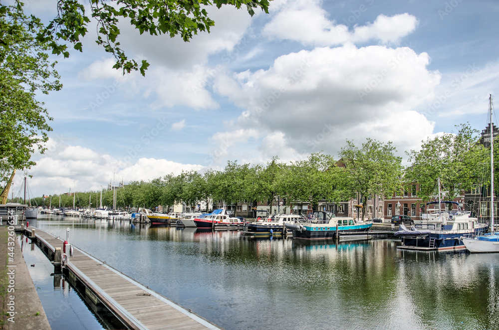 Vlaardingen, The Netherlands, July 4, 2021: view of the town's old harbour lined with yachts, trees and historic buildings