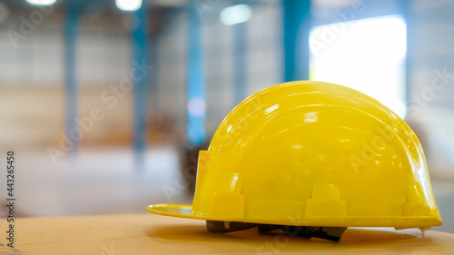 Close up of yellow engineering hat in warehouse, industry and factory concept.