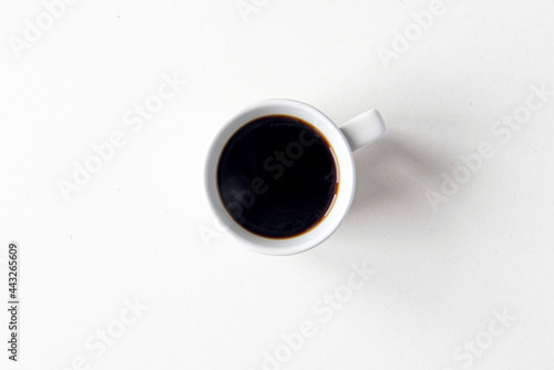 Ceramic mug with hot black coffee, top view as flat lay, space for text