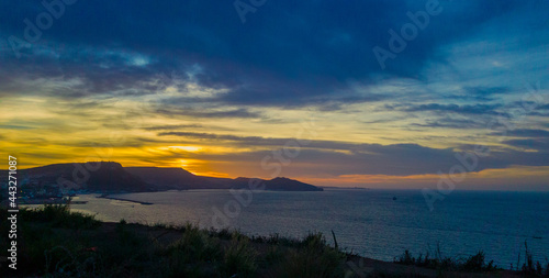 sunset above the sea, dramatic sky and sunset above the coast of Oran with moutains and jetty in the background. Tourism concept © Iceman_31