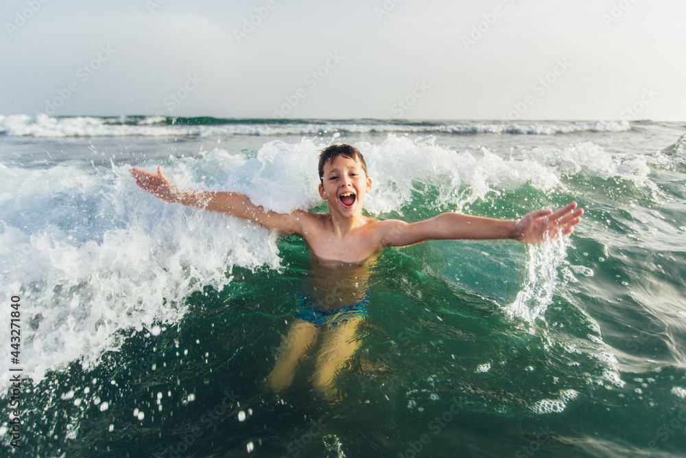 Happy child playing in the sea. Kid having fun outdoors. Summer vacation and healthy lifestyle concept. Selective focus