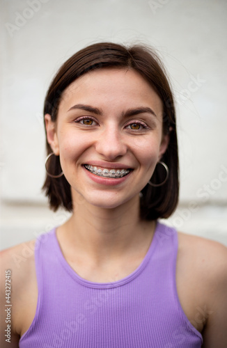 Young girl smiling with metal dental braces on teeth