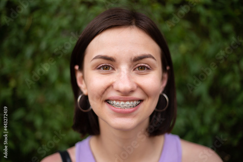 Young girl smiling with metal dental braces on teeth