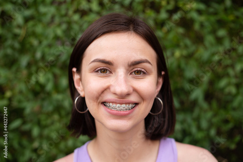 Young girl smiling with metal dental braces on teeth