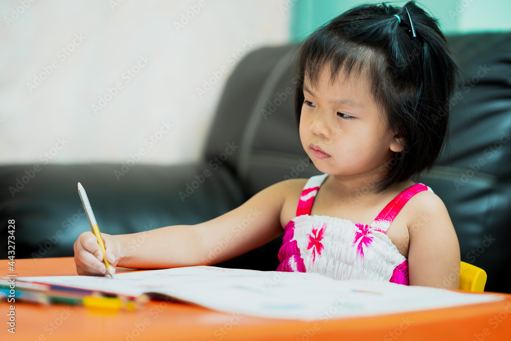 Asian child is sluggish having sleepiness while doing homework. Girl close half eyes. Cute kid aged 4-5 years old. Asian child is sluggish having sleepiness while doing homework. Girl close half eyes. Cute kid aged 4-5 years old.