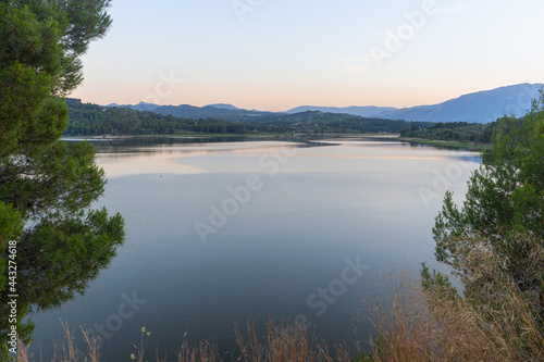 Beniarres's dam at dusk, with some reflections on the water, with a clear sky.