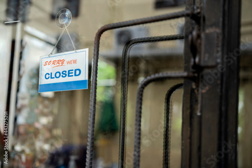 closed sign. grunge image hanging on a dirty glass door.