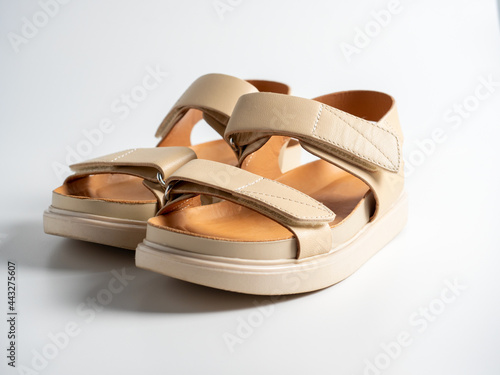 close-up of beige leather sandals on a white background. Pair of shoes, Women's flight shoes