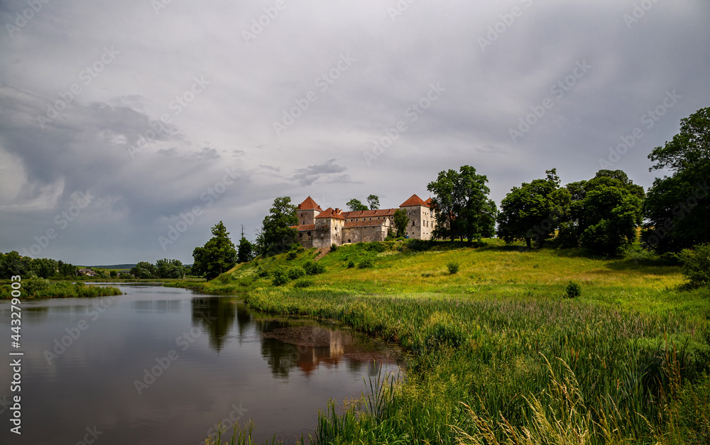 Naklejka premium Beautiful panorama of Svirzh castle by the river on a summer day, near Lviv.