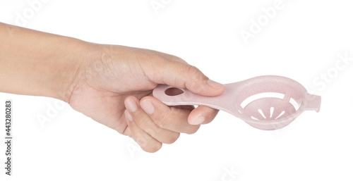 Hand holding Egg Separator Spoon plastic isolated on white background