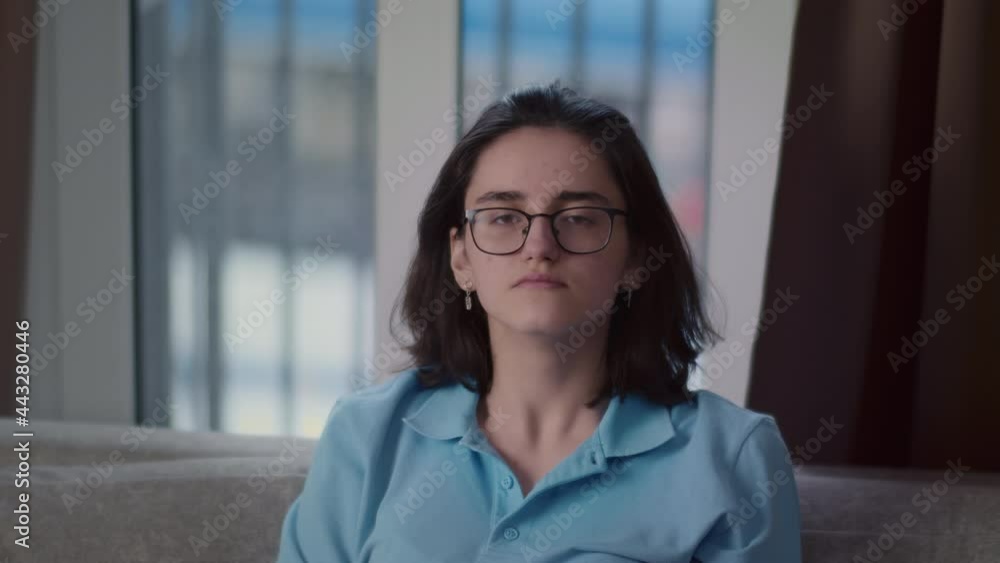 portrait of a brunette girl straightens her hair and looks at the camera against the background of a window at home, cinematic shot portrait of a brunette girl straightens her hair and looks at the camera against the background of a window at home, cinematic shot