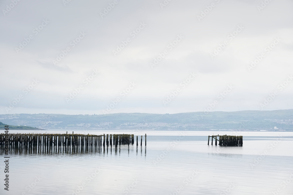 Old derelict wooden jetty pier in sea coastal town of Helensburgh