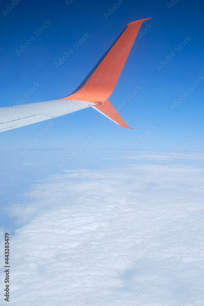 Fototapeta premium Airplane wing, scenic view from the window. Higher than clouds. Beautiful cloud, blue sky. Traveling by plane, adventure. Flight over Europe. Air transport. Aviation. Holiday in other country. Poster
