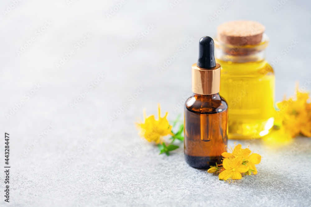 St. John's wort extract oil in a bottle on a gray background. Vegan food. Natural cosmetics St. John's wort extract oil in a bottle on a gray background. Vegan food. Natural cosmetics