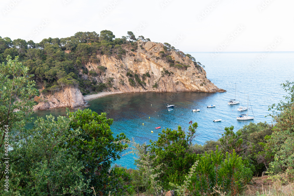 Remote and wild Mediterranean beach with boats