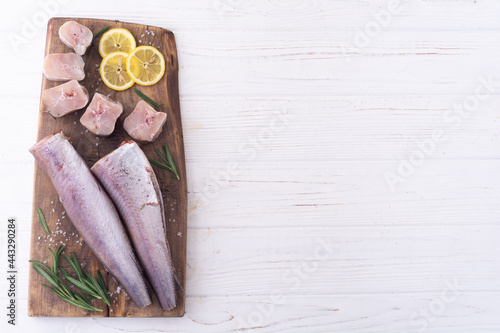 Raw hake on wooden background