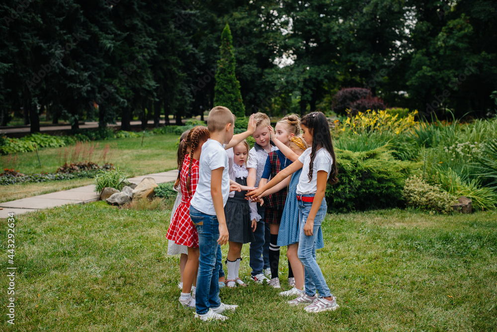 Obraz premium A group of children run around, have fun and play as a larger team in the summer in the Park. Happy childhood