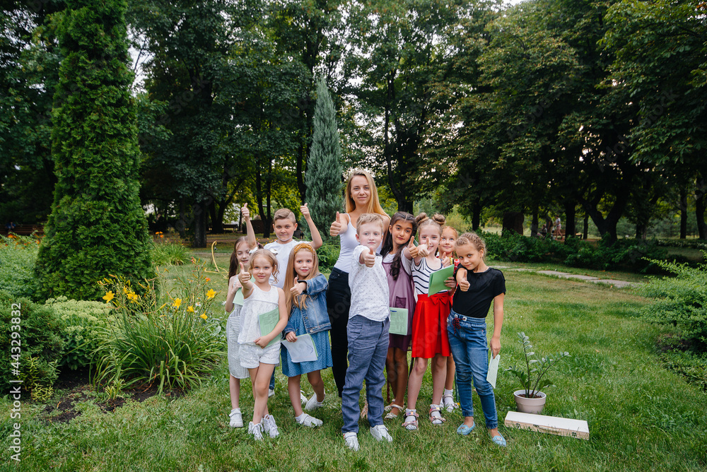 Fototapeta premium A teacher teaches a class of children in an outdoor Park. Back to school, learning during the pandemic