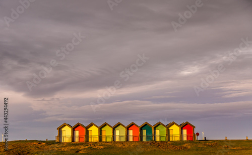 The vibrant and colorful beach huts by the promenade overlooking Blyth beach with a lovely sunset in Northumberland, England © Paul Jackson