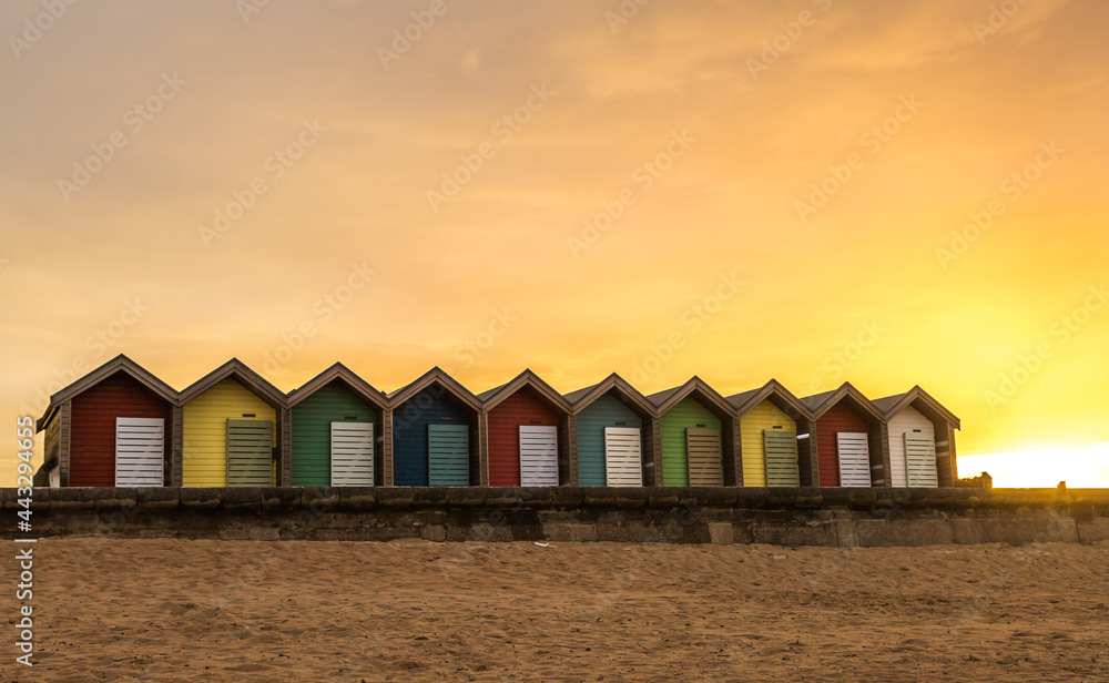 The vibrant and colorful beach huts by the promenade overlooking Blyth beach with a lovely sunset in Northumberland, England The vibrant and colorful beach huts by the promenade overlooking Blyth beach with a lovely sunset in Northumberland, England