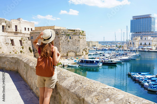 Apulia travels. Back view of young female backpacker in Gallipoli, Salento, Italy.