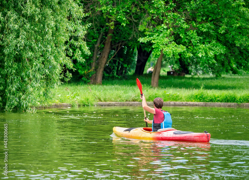 Man in a kayak paddling in Titan Park or Alexandru Ioan Cuza park. Man canoeing on a lake in Bucharest, Romania photo
