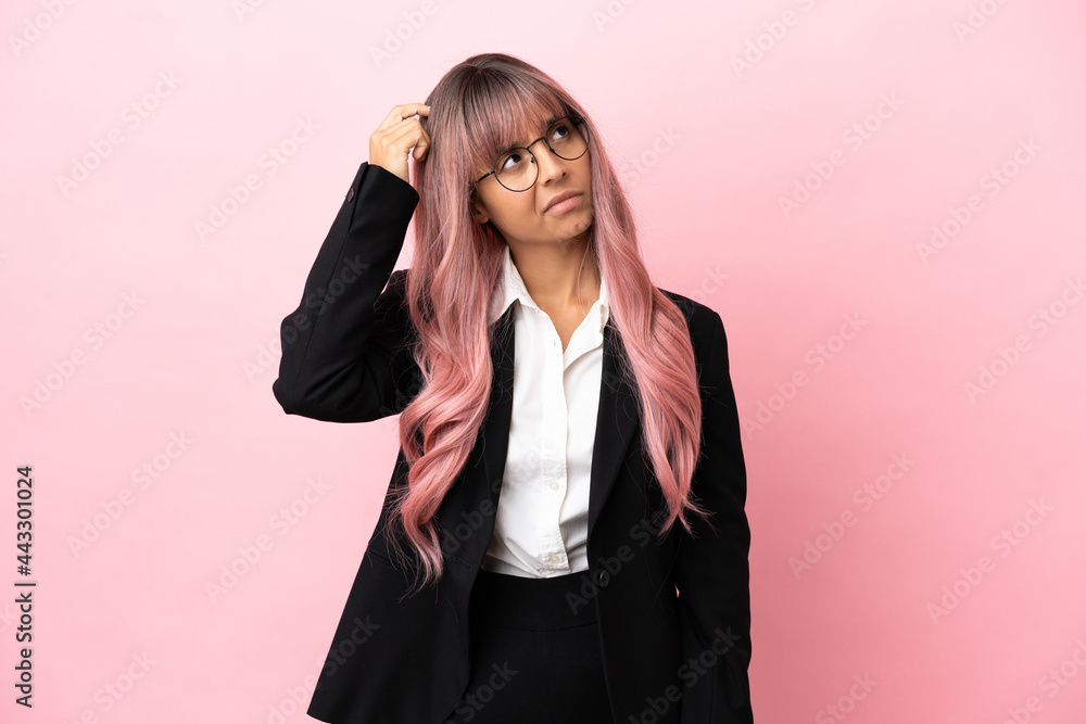 Young business mixed race woman with pink hair isolated on pink background having doubts and with confuse face expression Young business mixed race woman with pink hair isolated on pink background having doubts and with confuse face expression