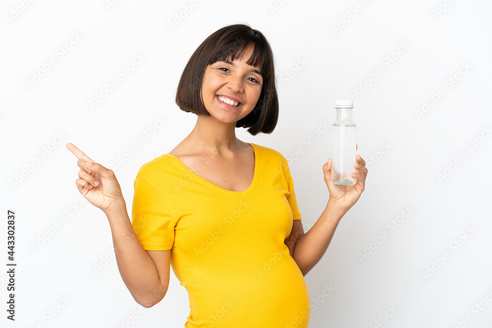 Young pregnant woman holding a bottle of water isolated on white background pointing finger to the side Young pregnant woman holding a bottle of water isolated on white background pointing finger to the side