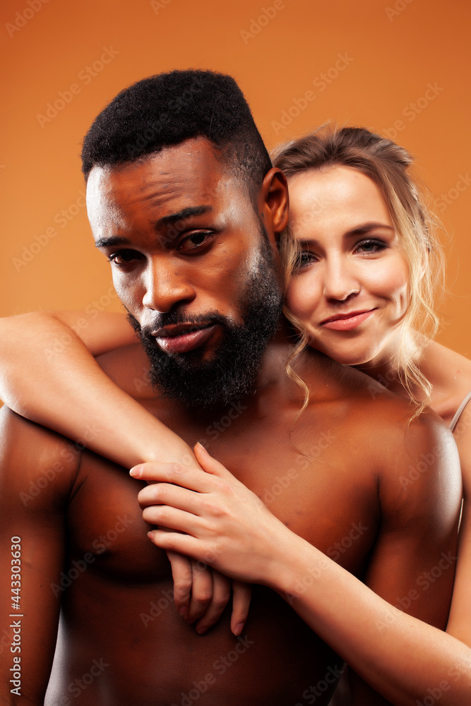 Young pretty couple diverse races together posing sensitive on brown background, lifestyle people concept