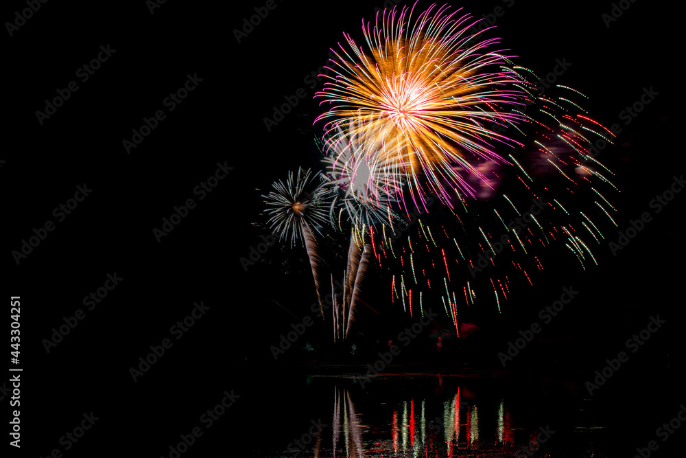 Holiday fireworks above water with reflection in the water