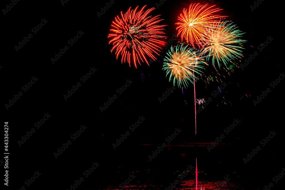 Holiday fireworks above water with reflection in the water