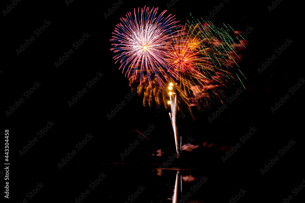 Holiday fireworks above water with reflection in the water