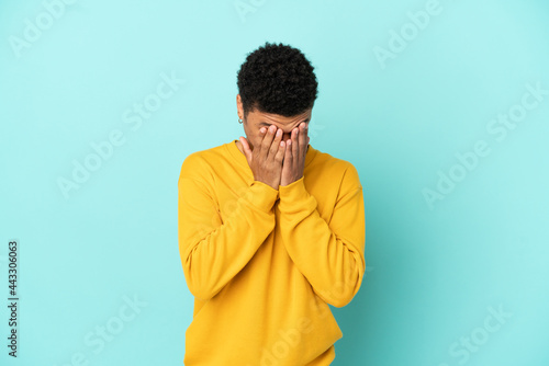 Young African American man isolated on blue background with tired and sick expression