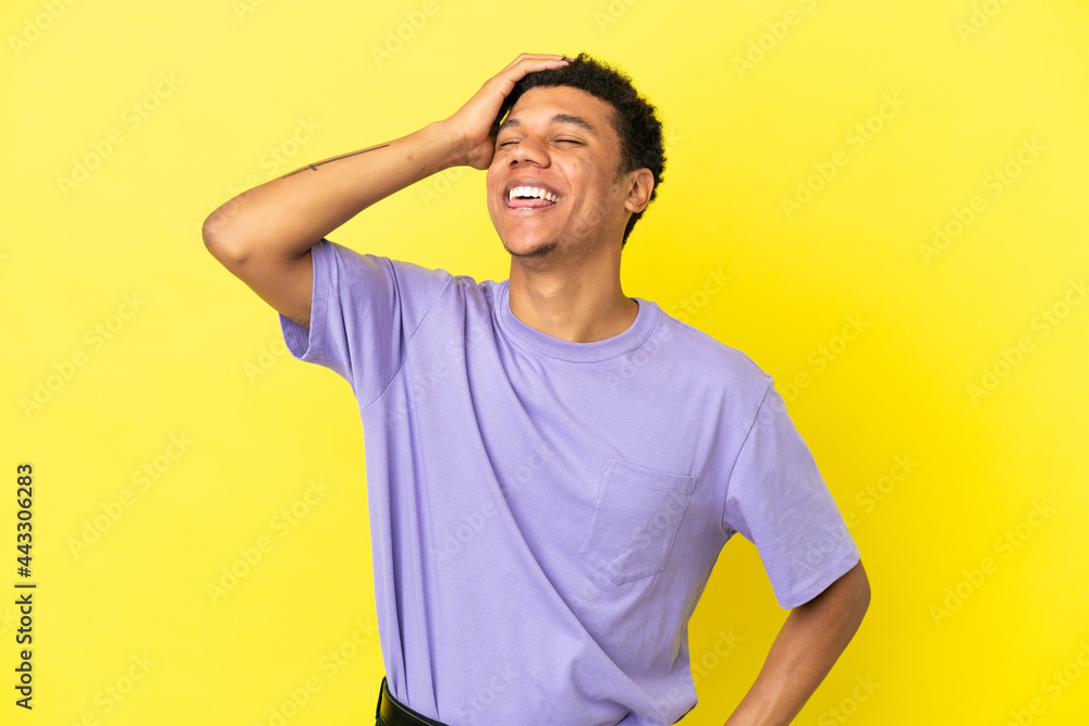 Young African American man isolated on yellow background smiling a lot Young African American man isolated on yellow background smiling a lot