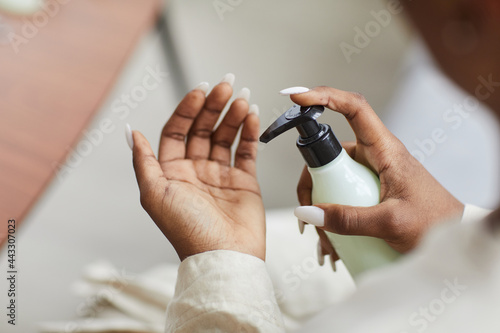 Close up of young African-American woman using hand cream or moisturizer  skincare and beauty routine concept  copy space