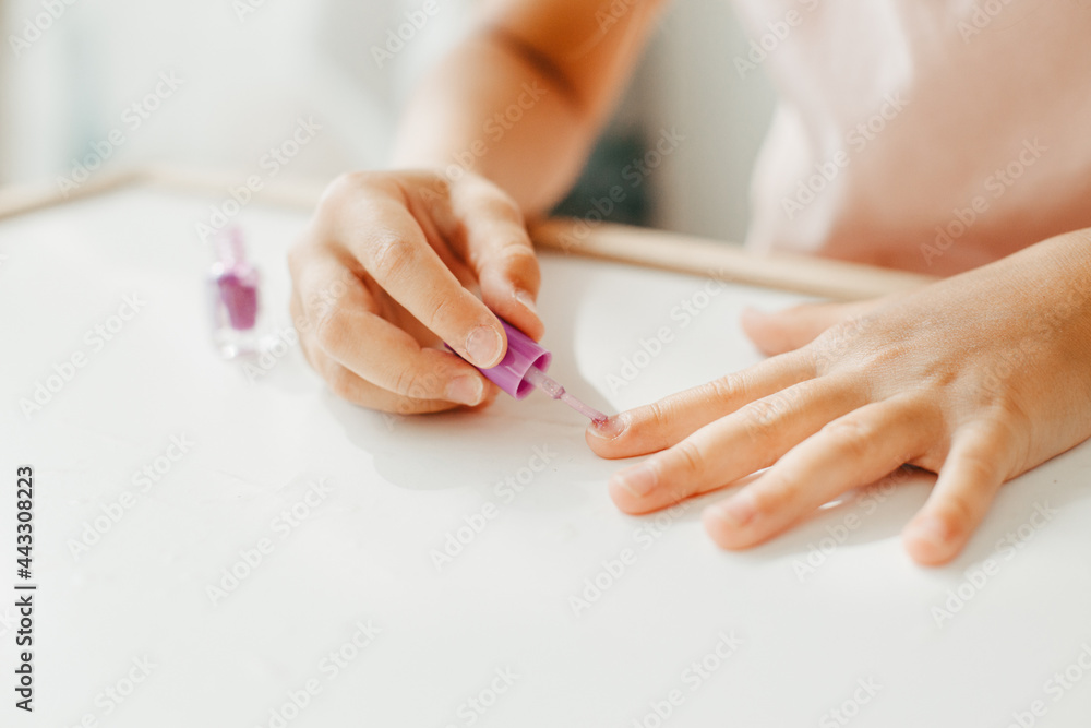 Six year preschooler girl with interest paint on nails with nail polish Six year preschooler girl with interest paint on nails with nail polish