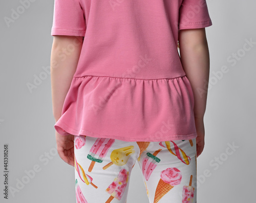 view from the back on a piece of clothing the children's summer clothes - pink cotton T-shirt with short sleeve and with the Basque and colorful Legency