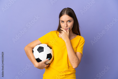 Young Lithuanian football player woman isolated on purple background thinking © luismolinero