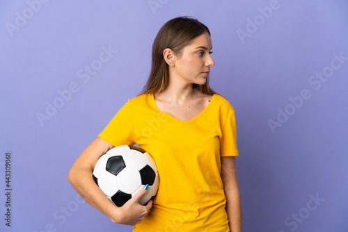 Young Lithuanian football player woman isolated on purple background looking to the side © luismolinero
