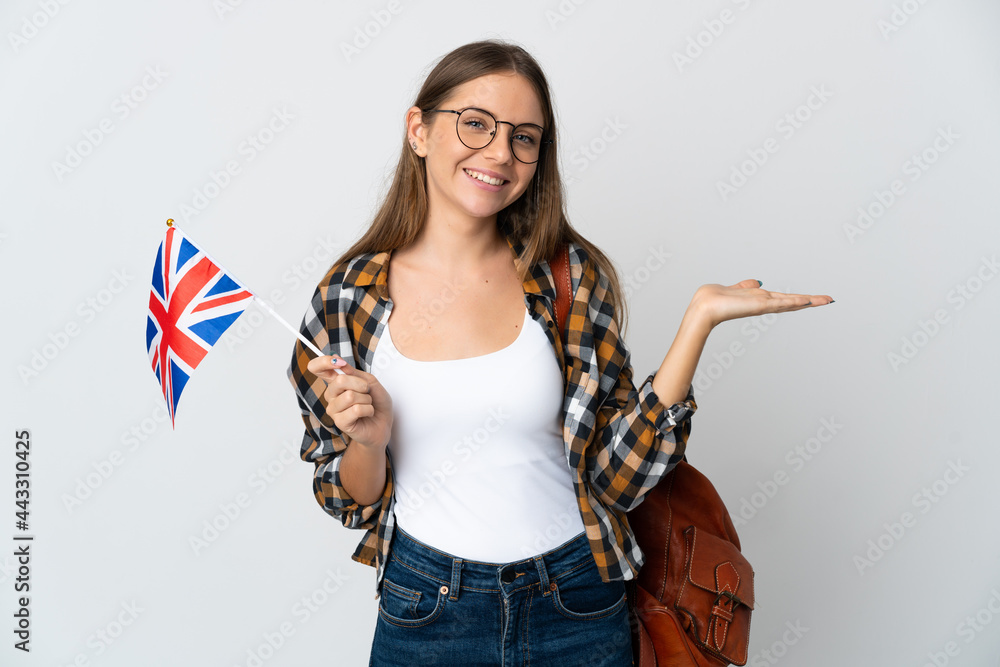 Young Lithuanian woman holding an United Kingdom flag isolated on white background holding copyspace imaginary on the palm to insert an ad - obrazy, fototapety, plakaty 